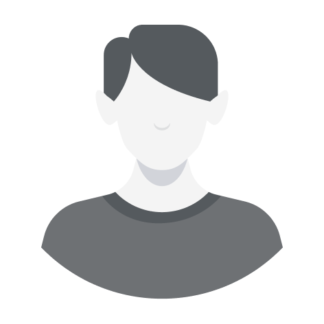 Woman with blonde hair and bangs smiling, wearing a green blouse, indoors.