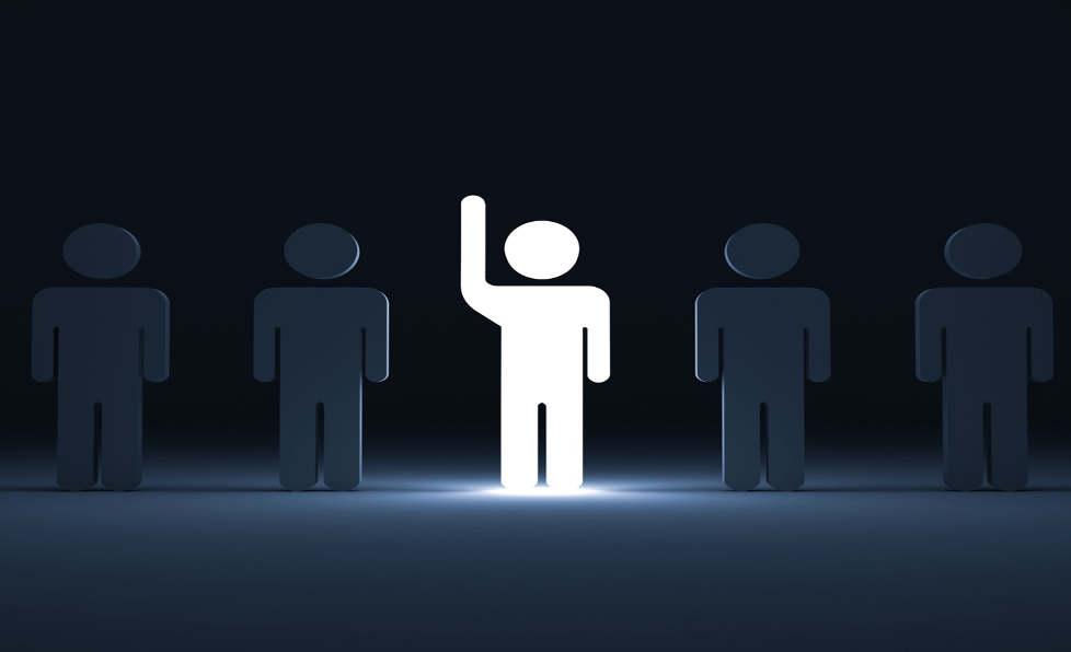 Bright figure with raised hand stands out among other figures in the dark.