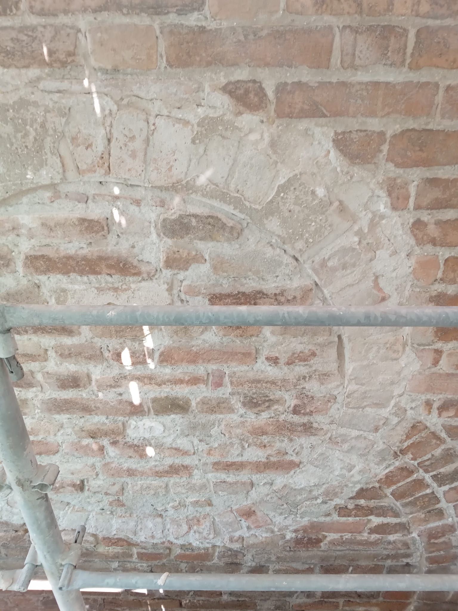 Soffitto in mattoni con sezione ad arco e impalcature.