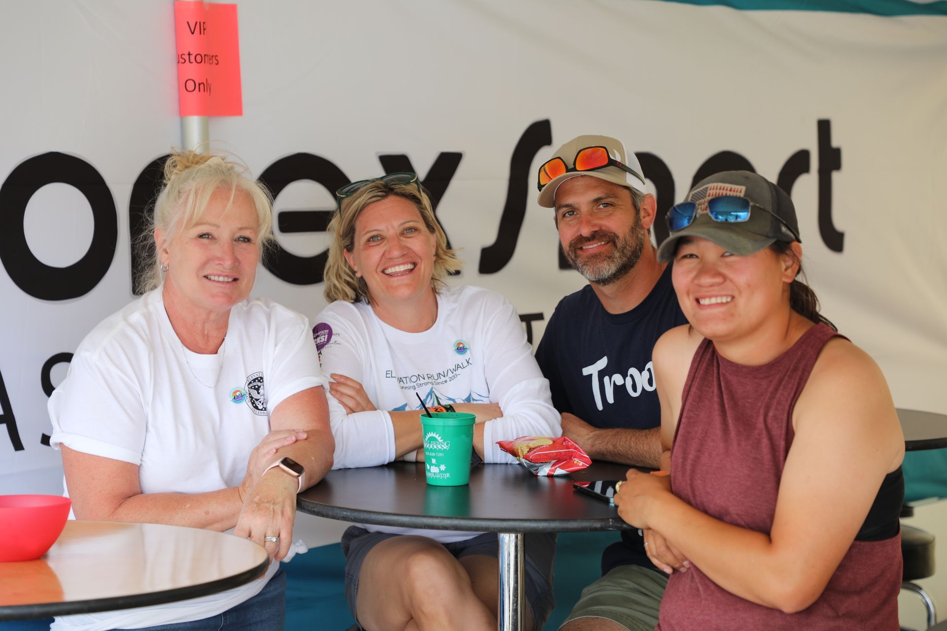 A group of people are posing for a picture while sitting at a table