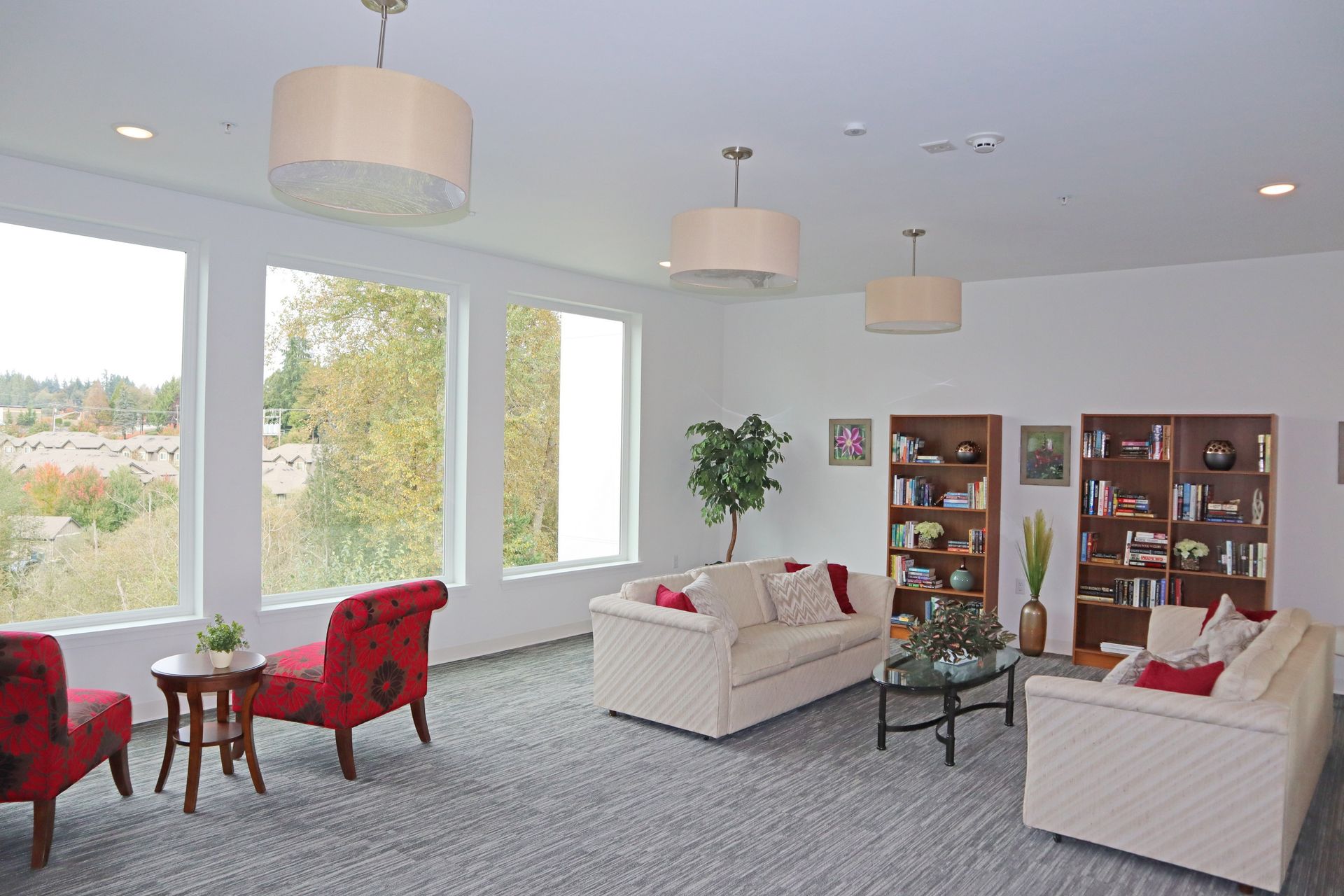 photo showing a living area large enough to fit two couches, books shelves, a table, and much more