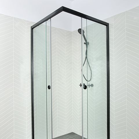 Modern white bathroom with double sink vanity, large mirror, and glass shower enclosure.