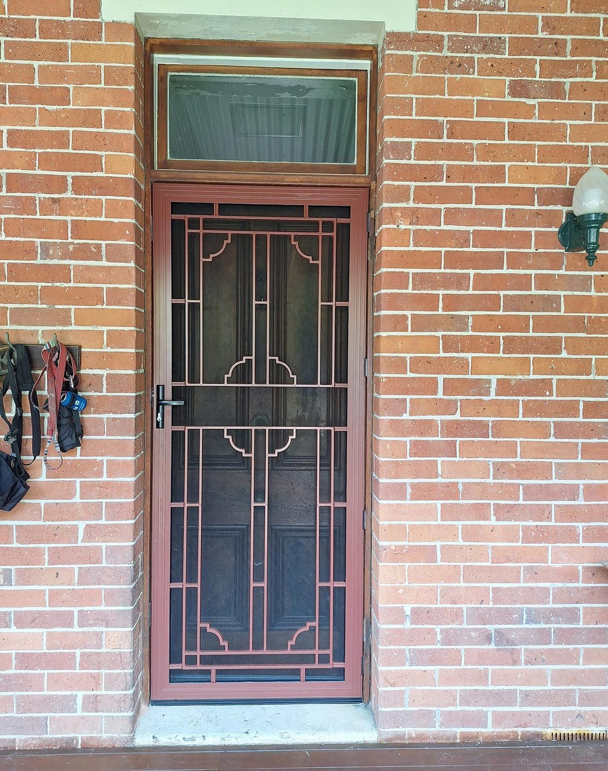 A brick building entrance with a metal security door and small window above.