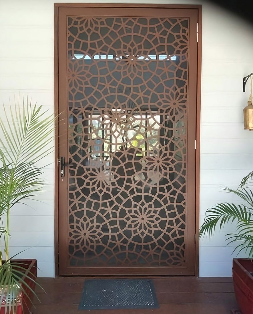 Brown decorative metal screen door with floral pattern.