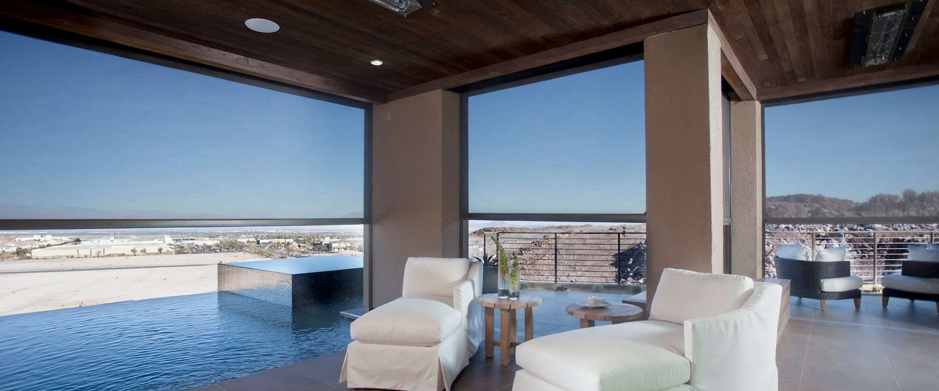 A worker installs a window frame indoors. He's wearing a tool belt and looking up at the frame.