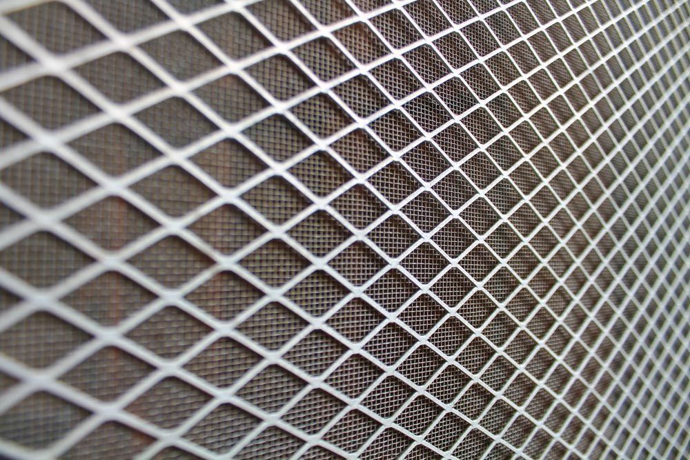 White diamond mesh over a darker, textured background, creating a grid pattern.