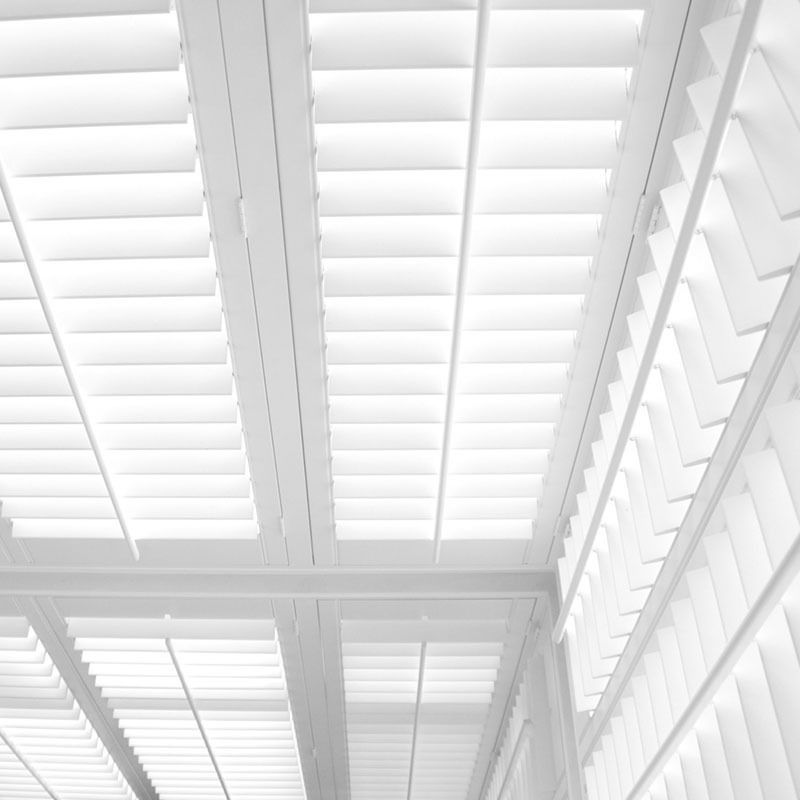 Two gray roll-down security shutters; one partially open, one closed.