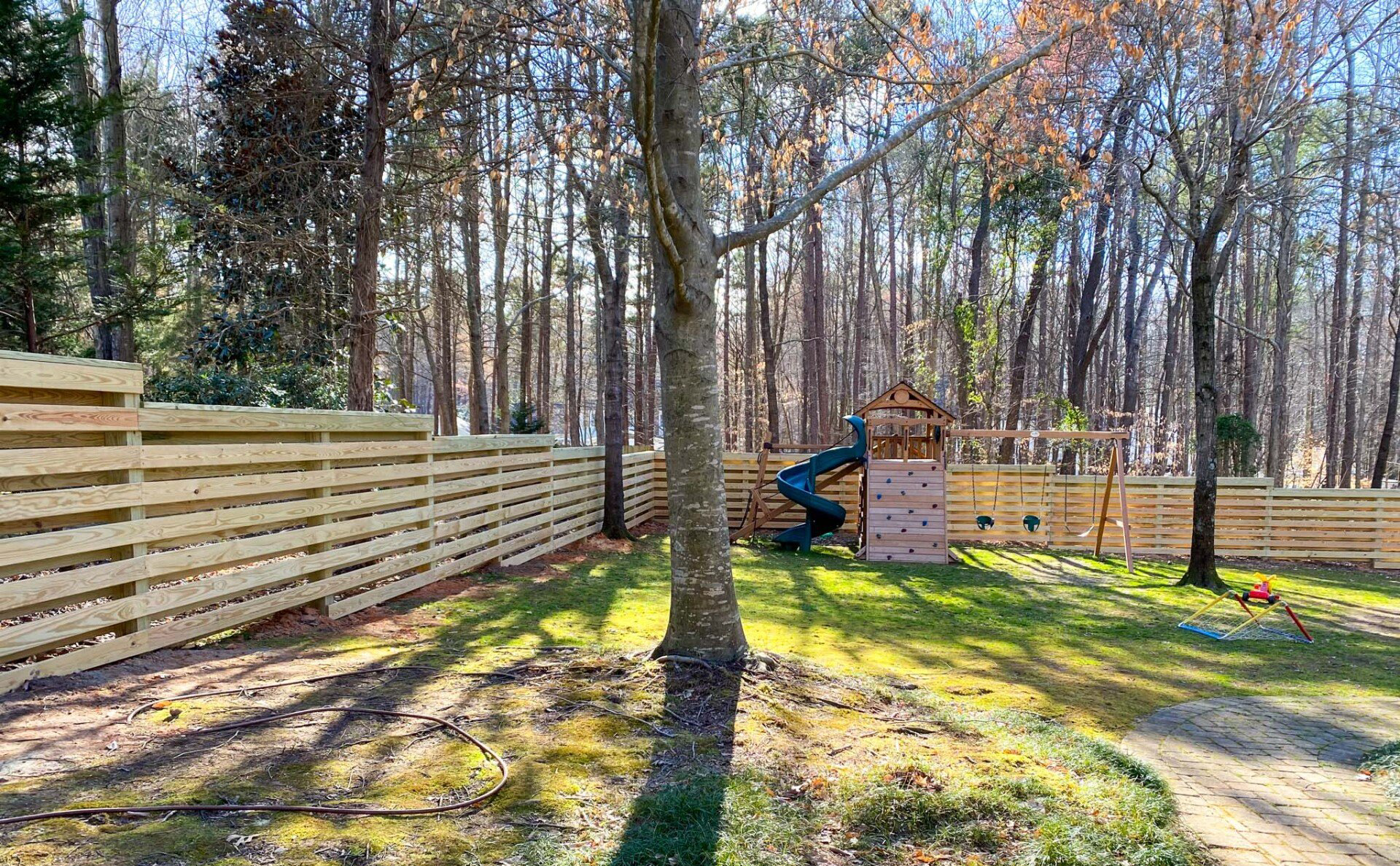 Wooden privacy fence surrounding a residential backyard.