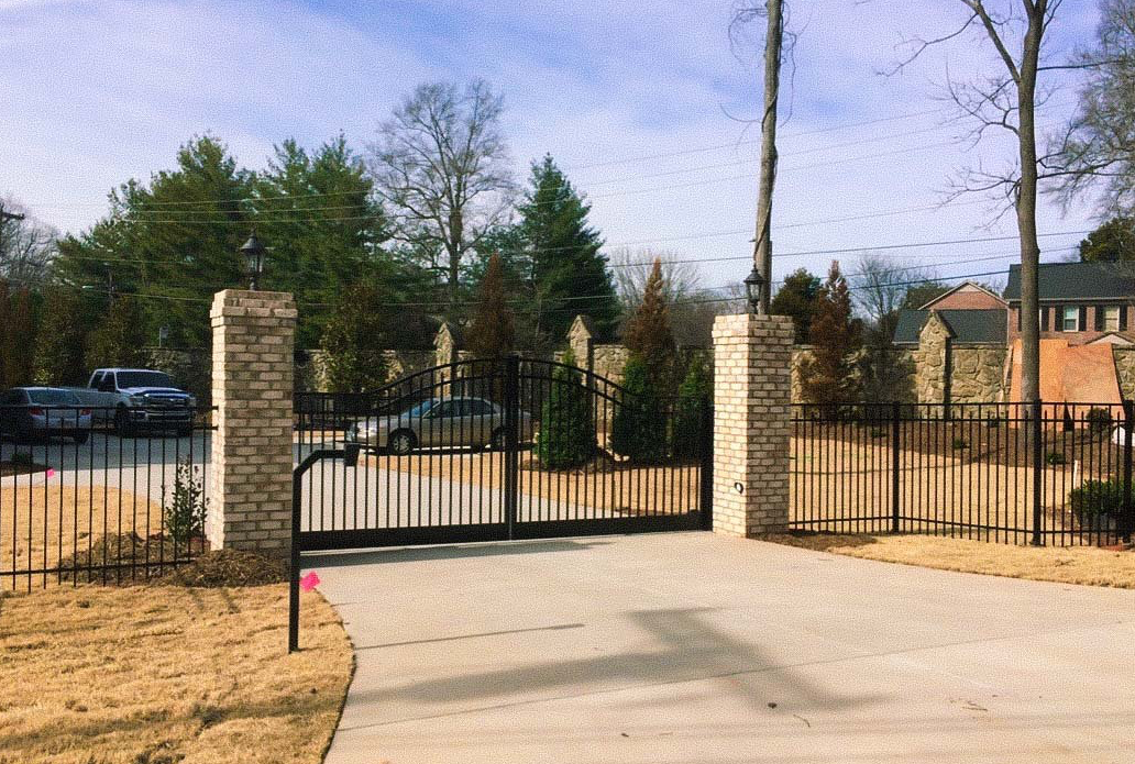 White vinyl fence enclosing a landscaped garden area.