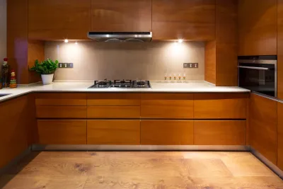 Grande Prairie Handyman: Modern kitchen with wooden cabinets and countertops. Gas stovetop, oven, and recessed lighting.
