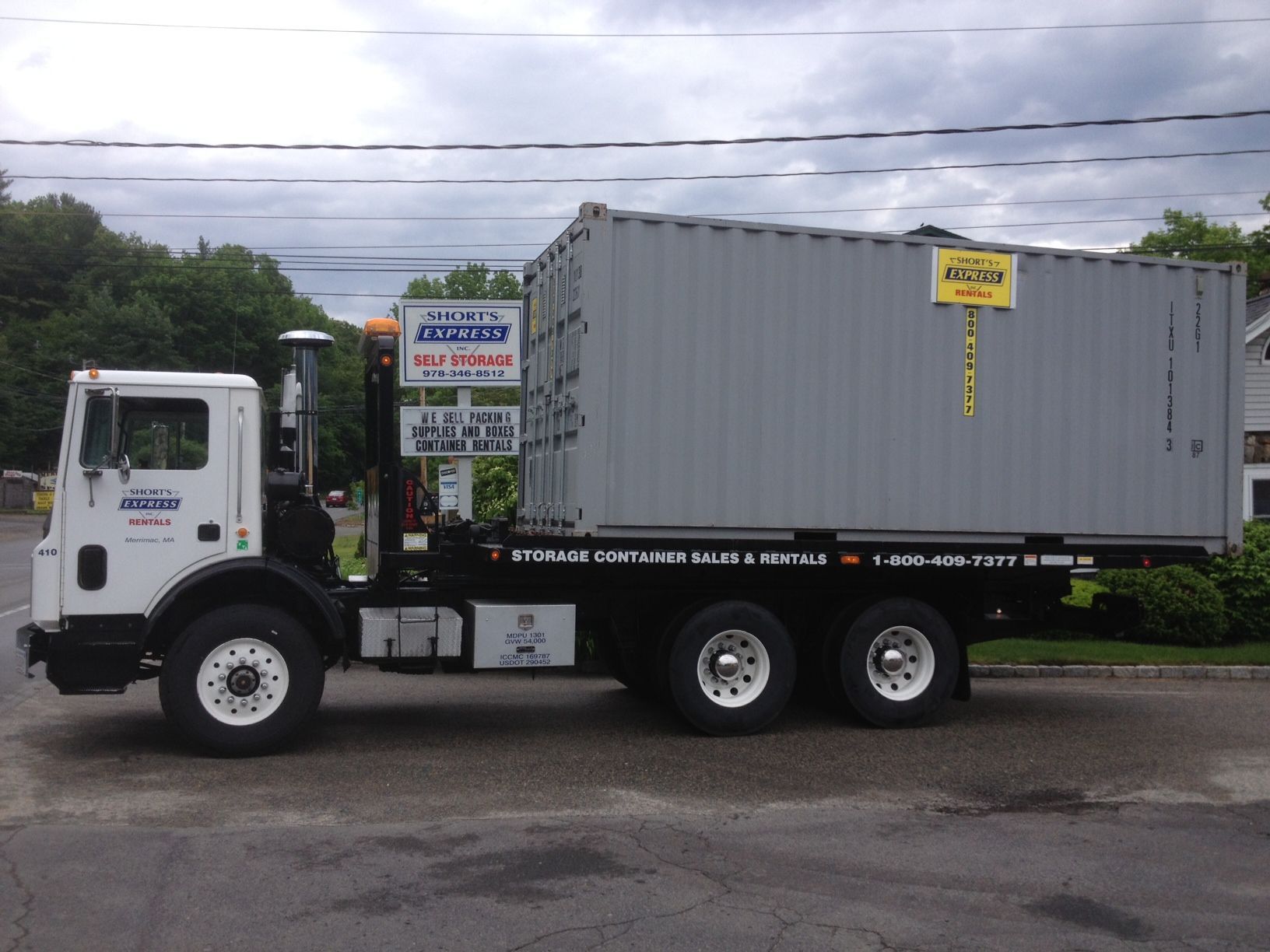 A tow truck is carrying a large shipping container
