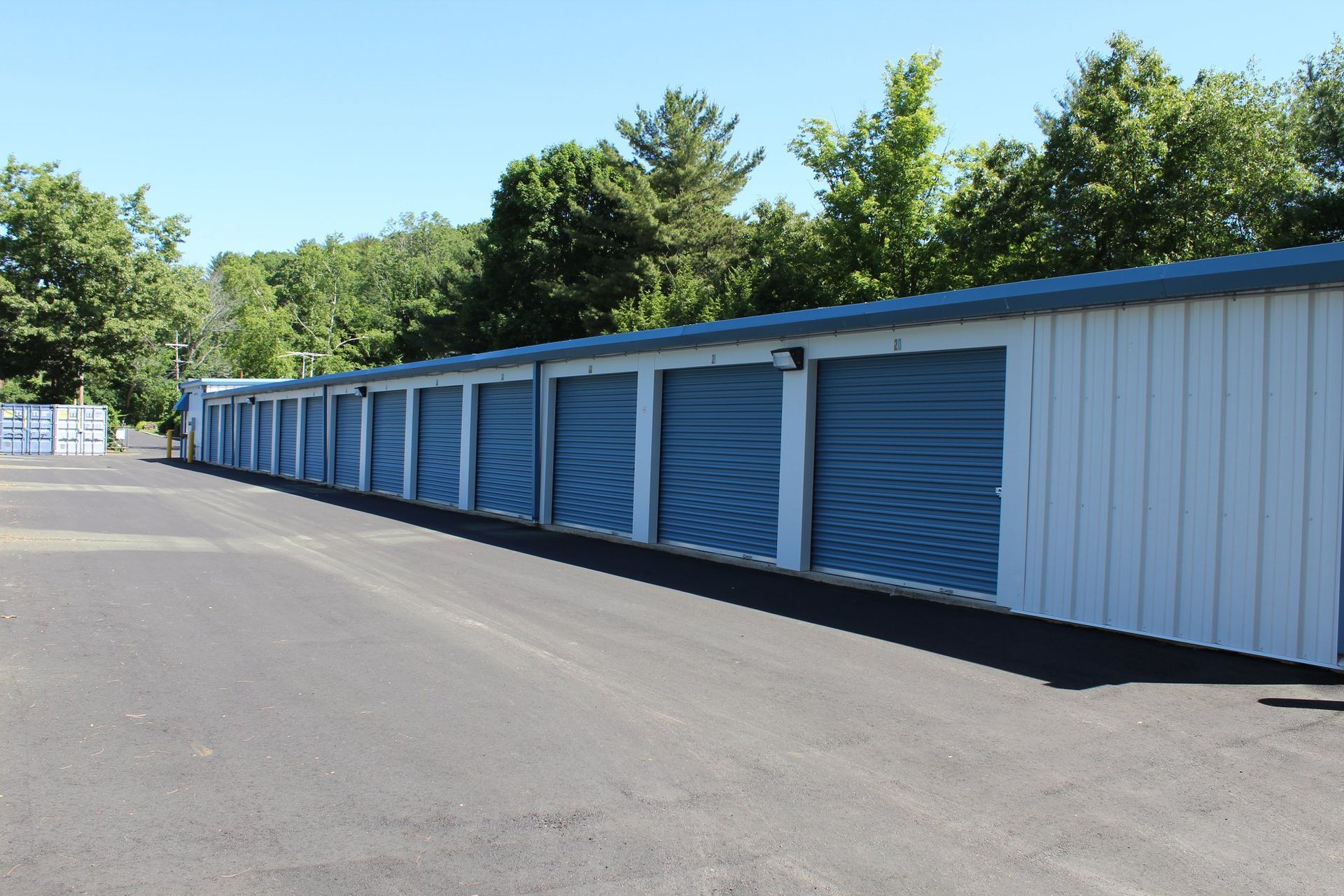 A row of storage units with blue doors on a sunny day