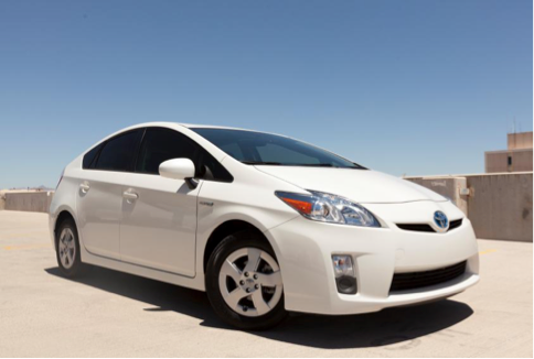 A white toyota prius is parked in a parking lot