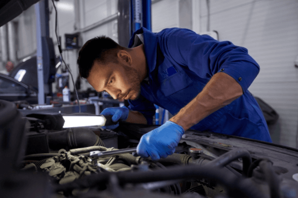 A man is working on a car engine in a garage.