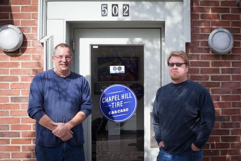Two men standing in front of chapel hill tire