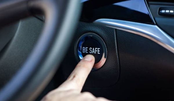 A person is pressing a be safe button in a car