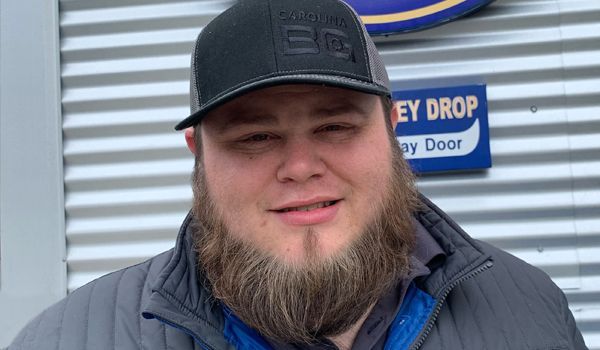 A man with a beard is wearing a hat and jacket.