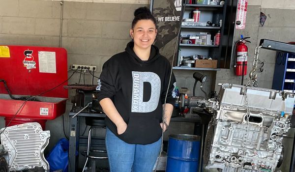 A woman wearing a black shirt with the letter d on it