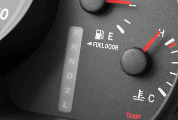 A close up of a car dashboard showing the fuel door
