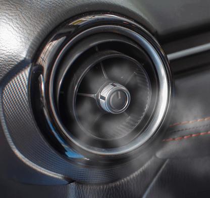 A close up of a car air vent with steam coming out of it
