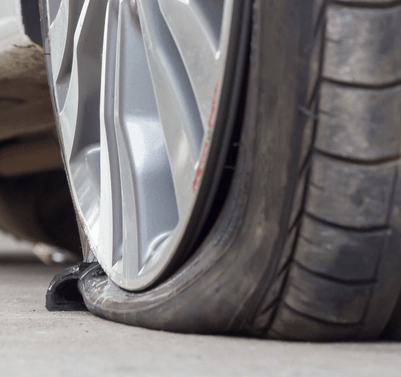 A close up of a flat tire on a car