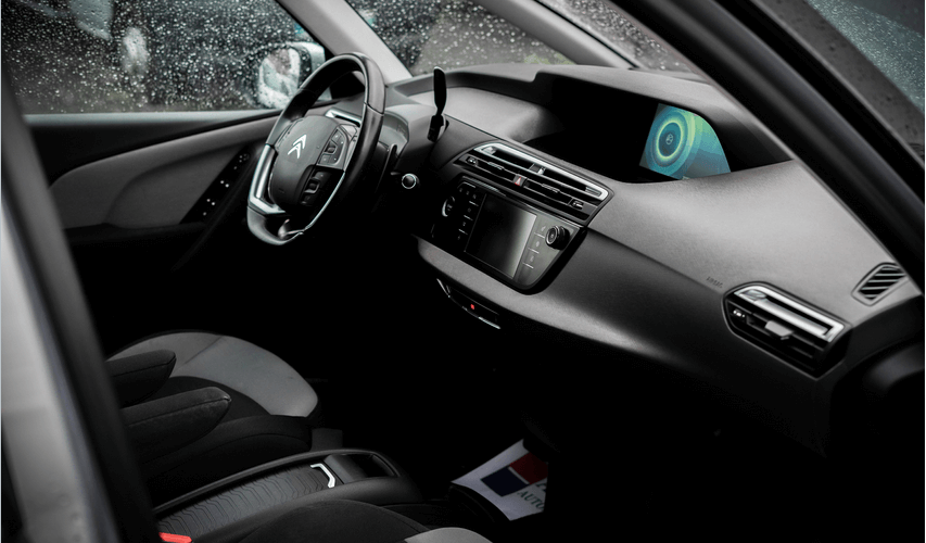 The inside of a car with a steering wheel and dashboard