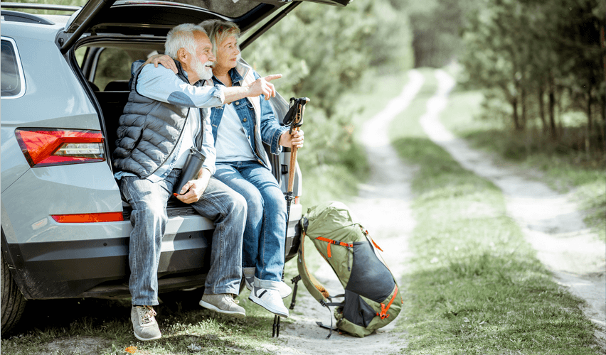 A man and a woman are sitting in the back of a car.