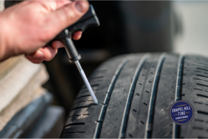 A person is fixing a tire with a screwdriver
