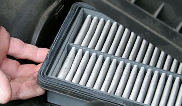 A person is holding a air filter in their hand.