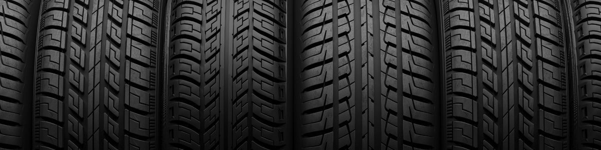 A row of black tires are stacked on top of each other.