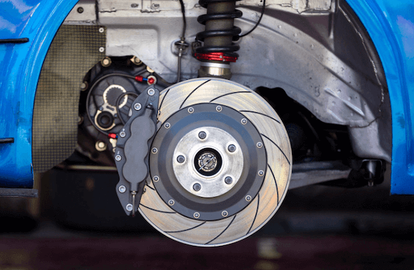 A close up of a brake disc on a blue car