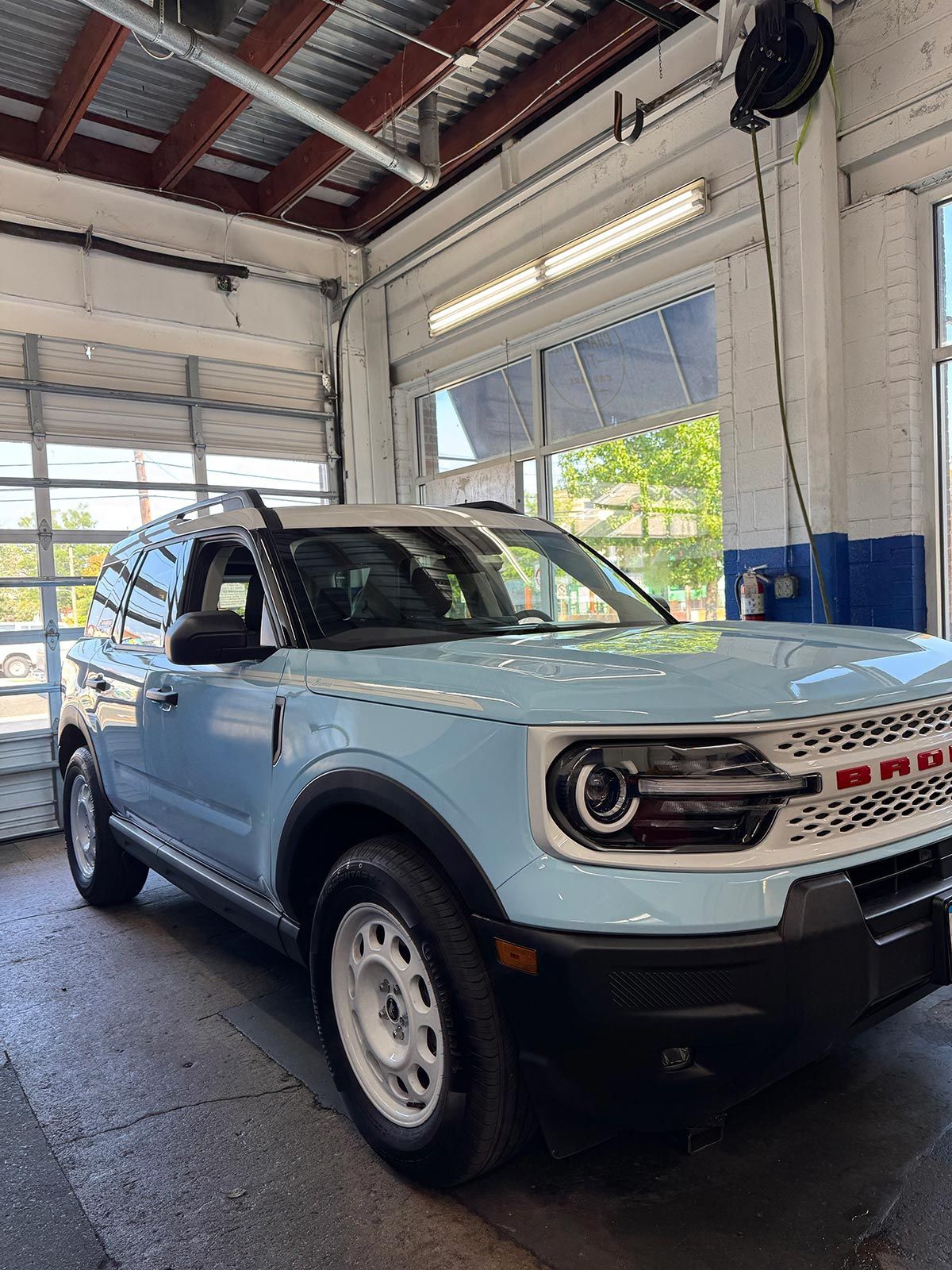 Light blue Ford Bronco Sport in a car wash bay.