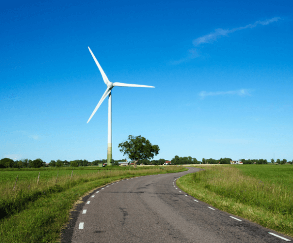 A wind turbine on the side of a road