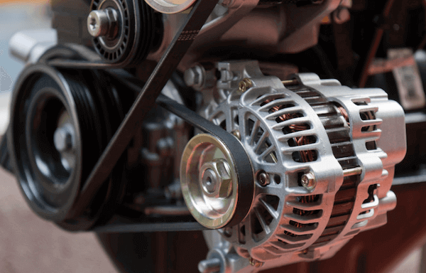 A close up of an alternator on a car engine