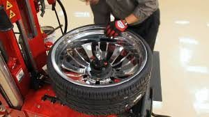 A man is changing a tire on a machine.