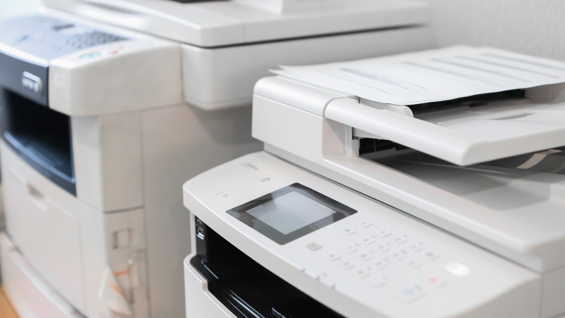 A couple of printers sitting next to each other on a table.