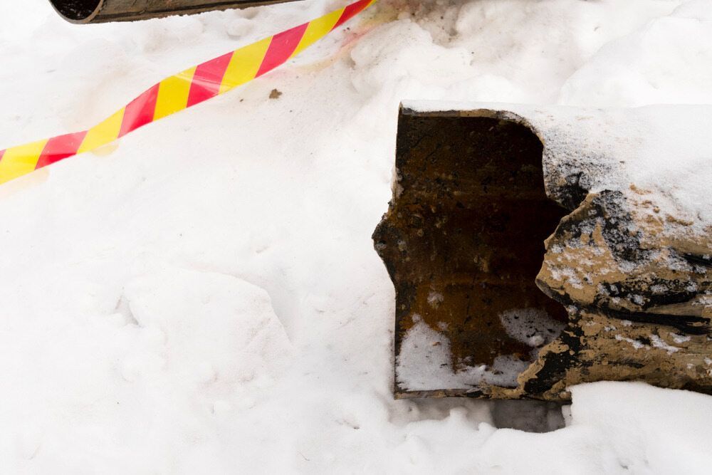 A Shovel Is Sitting In The Snow Next To A Red And Yellow Tape — Chad Taylor Plumbing In Forster, NSW