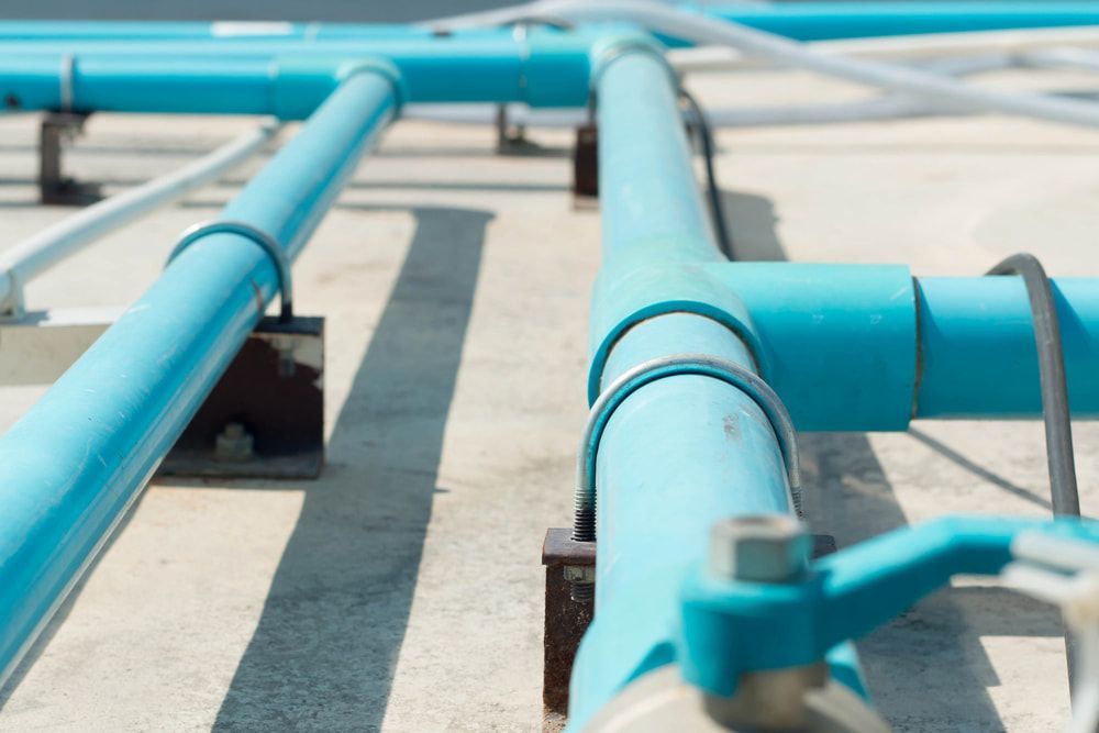 A Bunch Of Blue Pipes Are Connected To Each Other On The Ground — Chad Taylor Plumbing In Forster, NSW