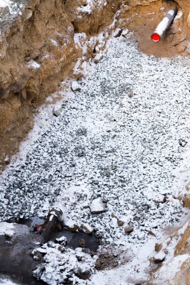 A Pile Of Rocks Covered In Snow Next To A Pipe — Chad Taylor Plumbing In Forster, NSW