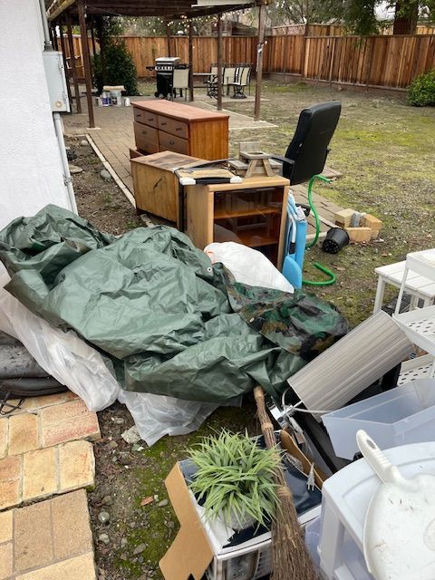 A pile of junk in the backyard of a house