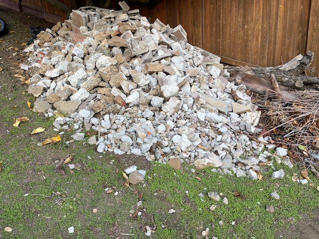 A pile of rocks is sitting on top of a lush green field.