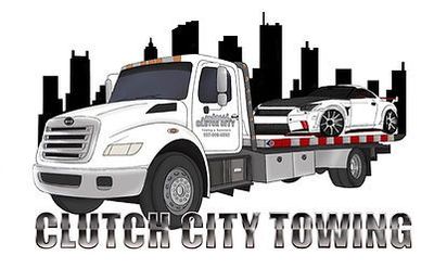 A tow truck is towing a car in front of a city skyline.