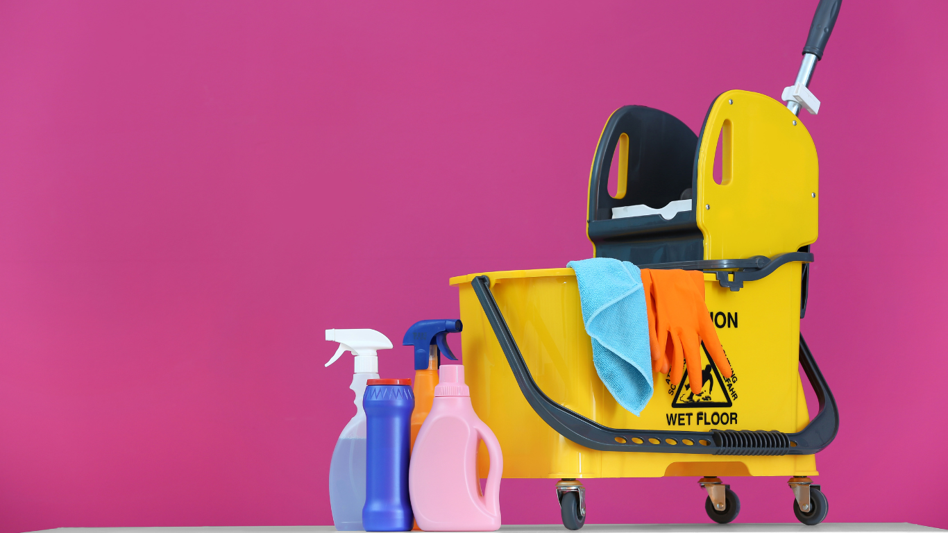 a yellow mop bucket and cleaning supplies are on a table .