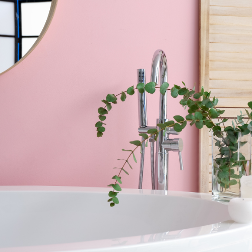 a bathtub with a faucet and a plant in it