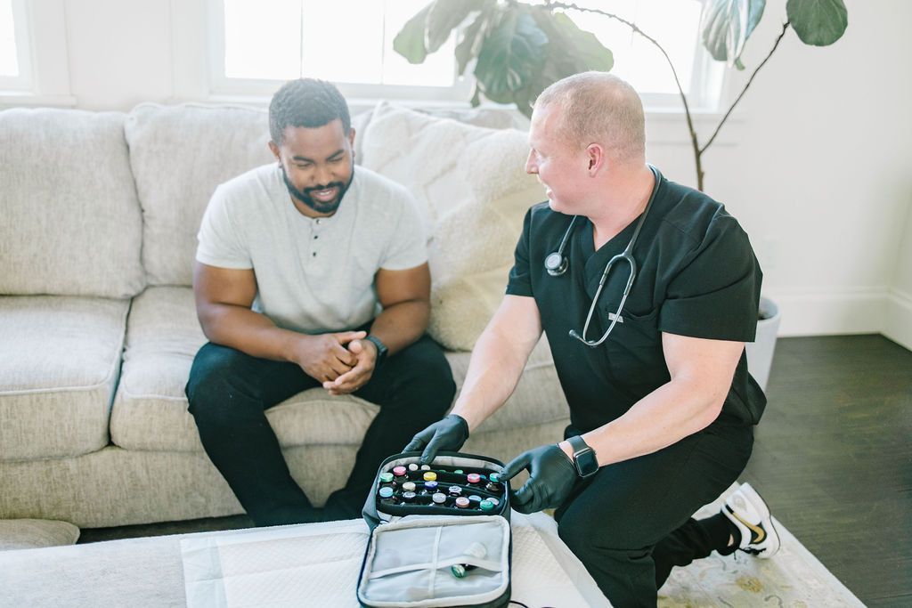 A man is sitting on a couch talking to a doctor.