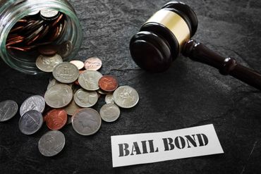 currency coins with a gavel and bail bond printed paper lying on table