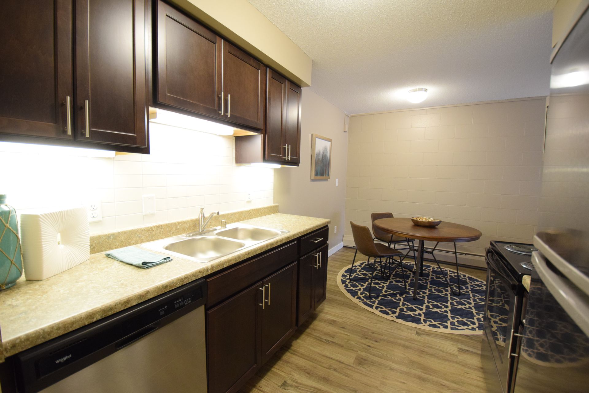 A kitchen with stainless steel appliances and wooden cabinets.