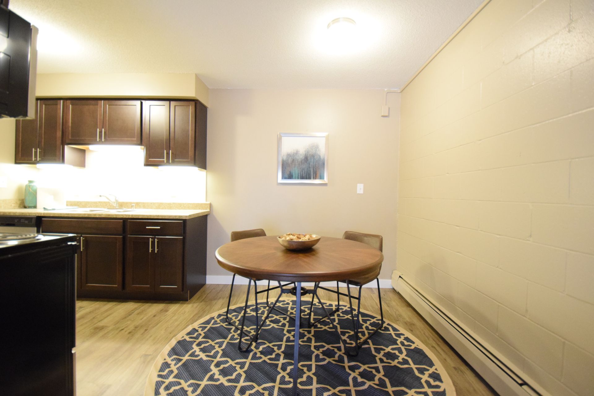 A kitchen with a round table and chairs in it