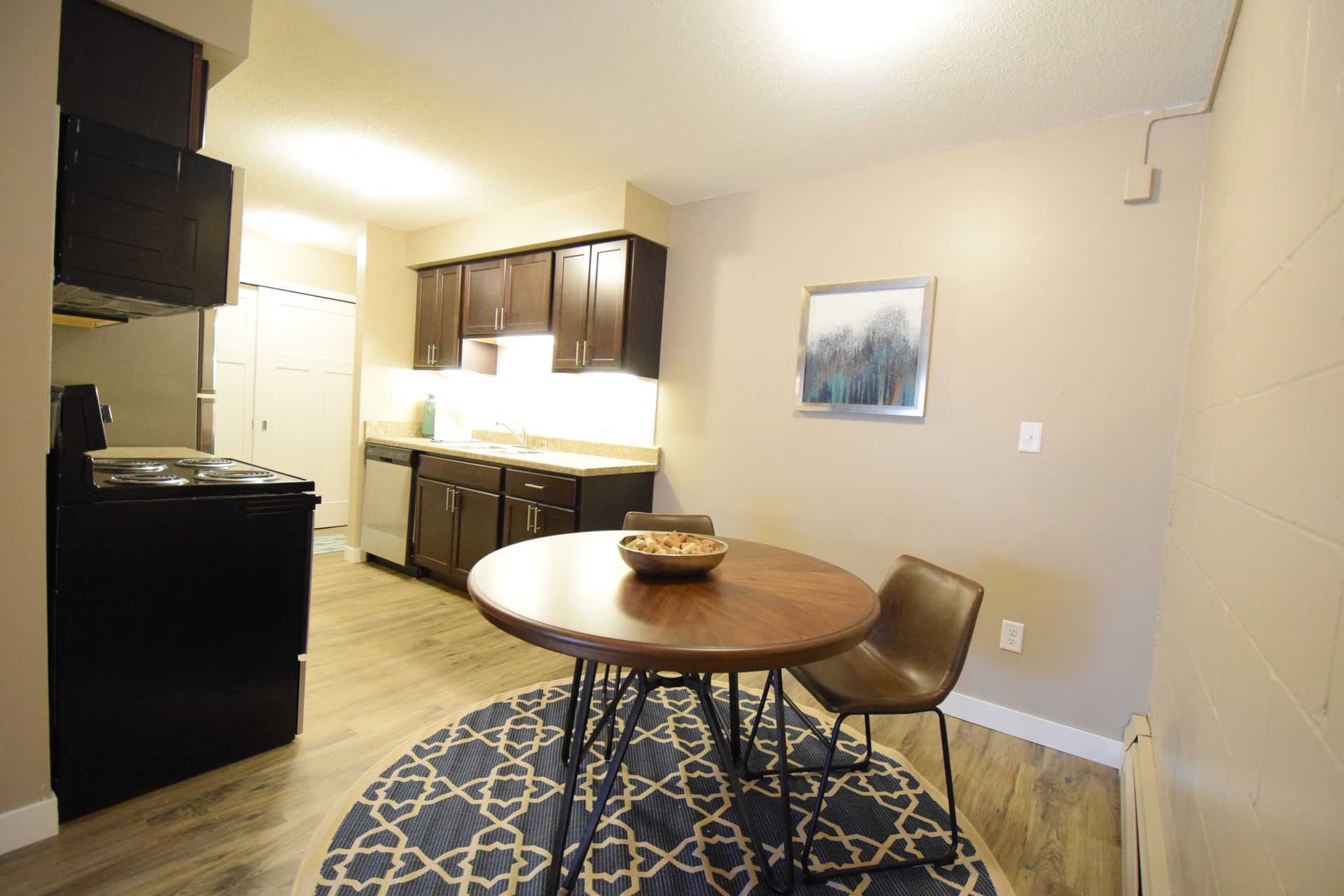 A kitchen with a round table and chairs in it.