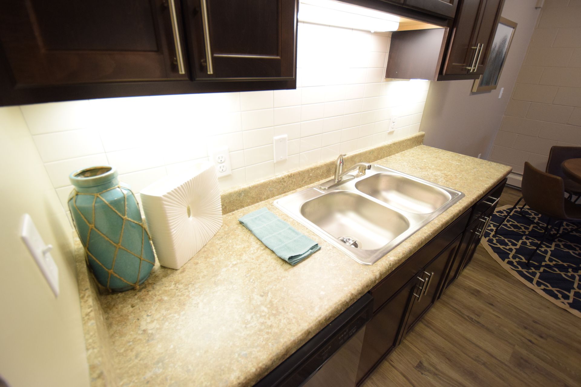 A kitchen with a sink and a vase on the counter.